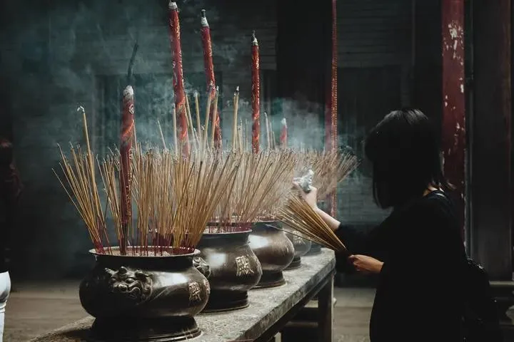 Incense sticks burning in bronze urns as an offering at a temple